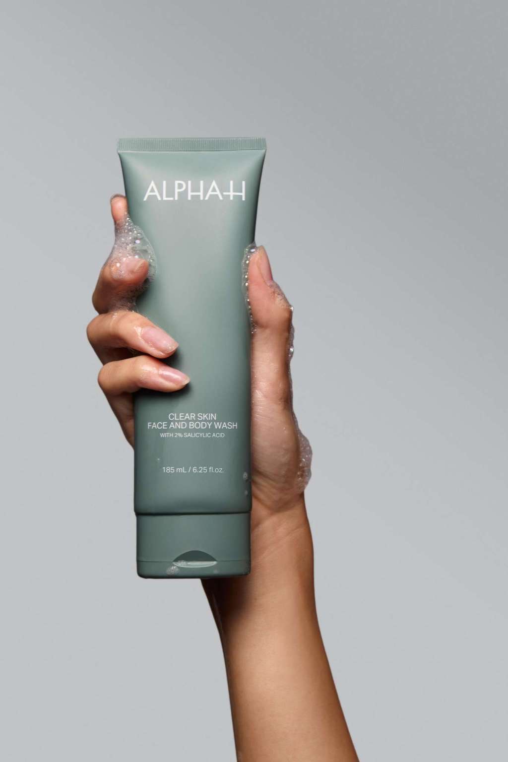 Alpha-H Clear Skin Face & Body Wash tube in de hand
