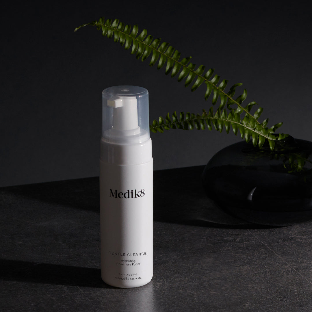Medik8 Gentle Cleanse flacon op donkere achtergrond met varen