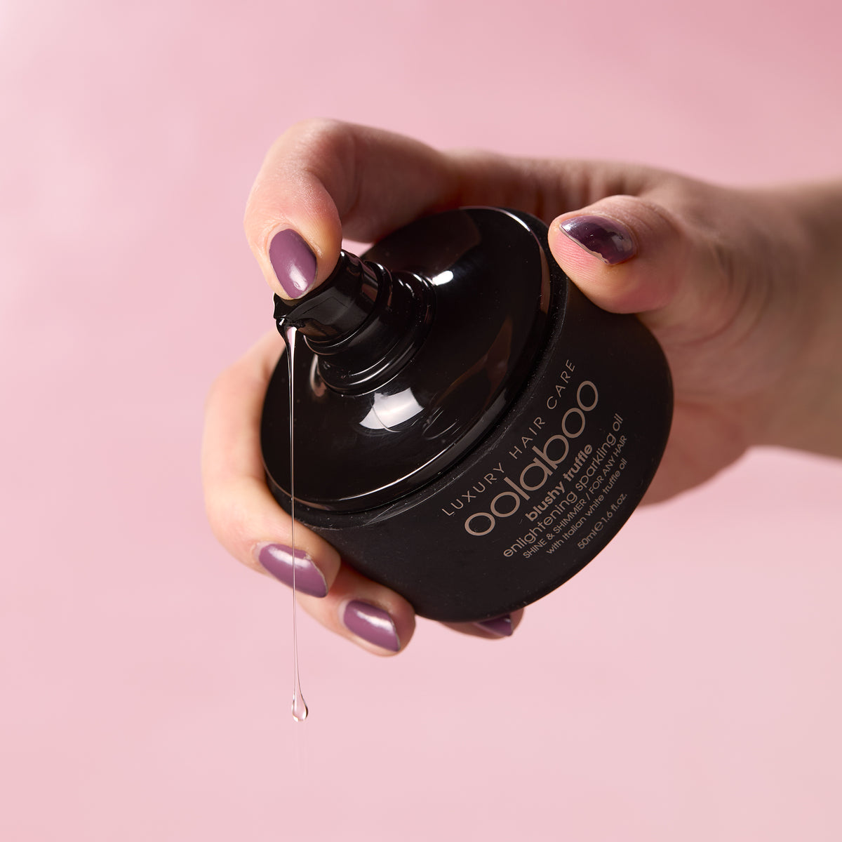 Oolaboo Blushy Truffle Sparkling Oil pomp met druppel olie in de hand