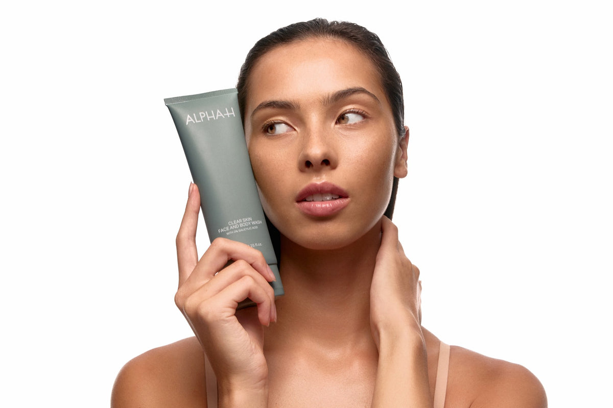 Alpha-H Clear Skin Face & Body Wash model met tube bij het gezicht