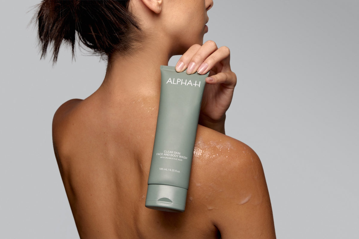 Alpha-H Clear Skin Face & Body Wash schuim op de schouder