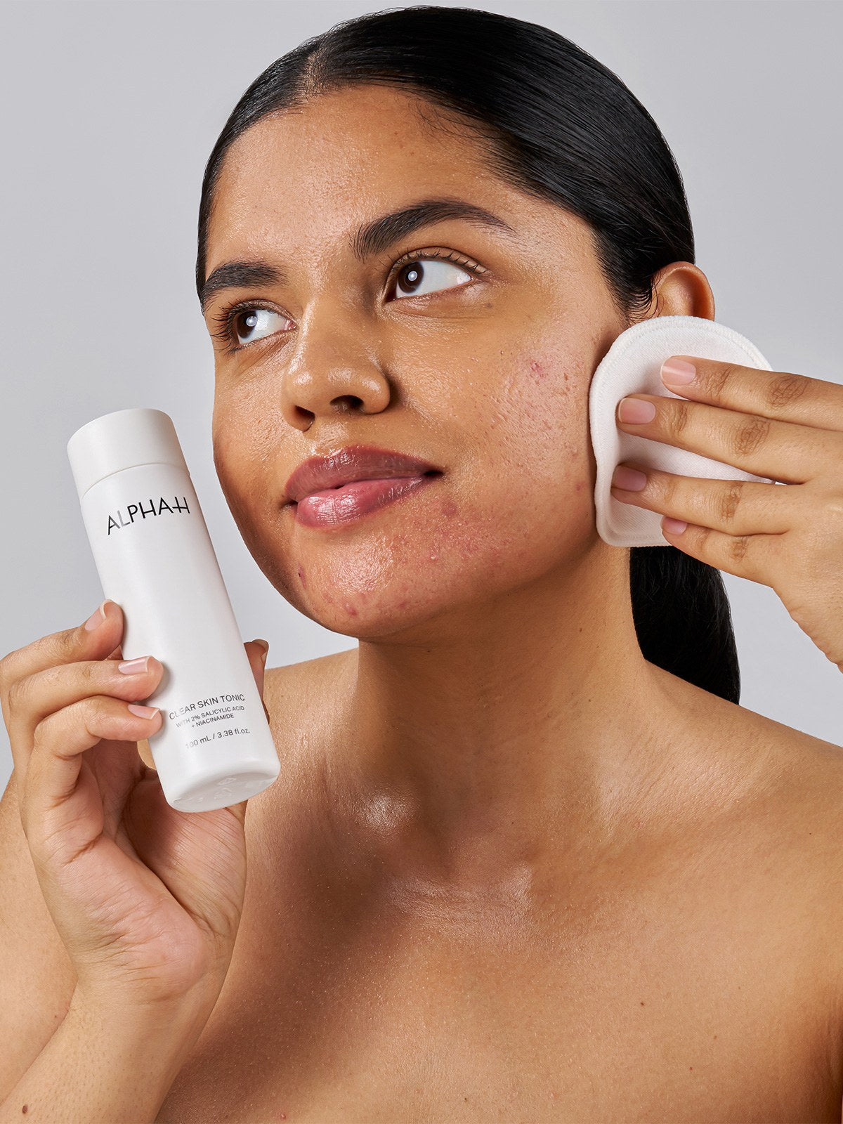 Alpha-H Clear Skin Tonic aanbrengen met wattenschijfje