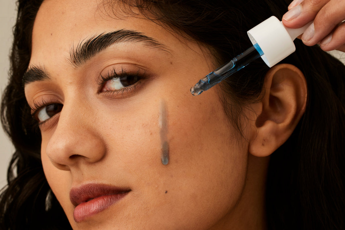 Alpha-H Vitamin B Serum model met serum op de wang