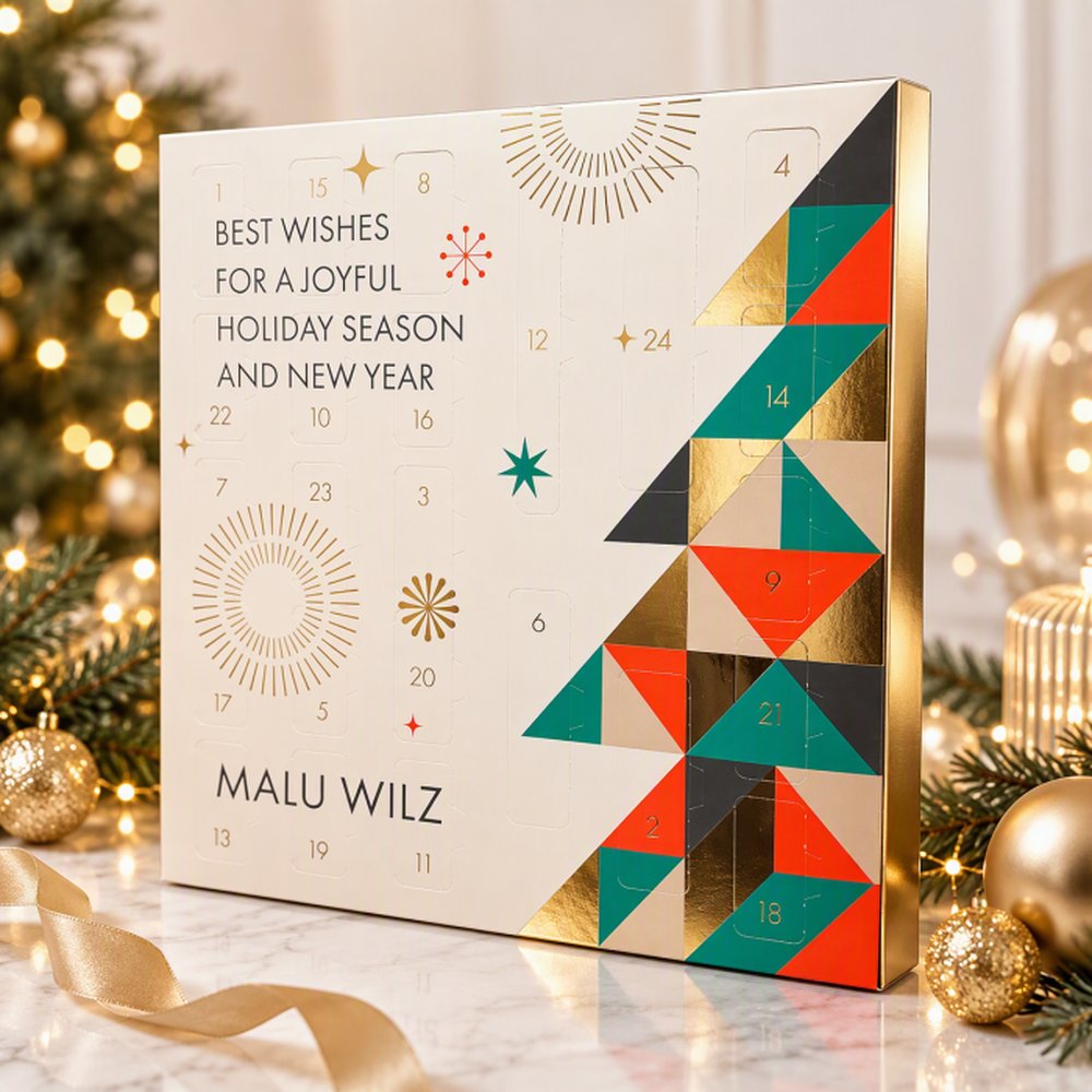 Malu Wilz Adventskalender 2026 bij kerstboom met gouden kerstballen