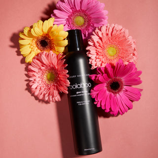 Oolaboo Glam Former Dry Shampoo tussen roze gerbera's