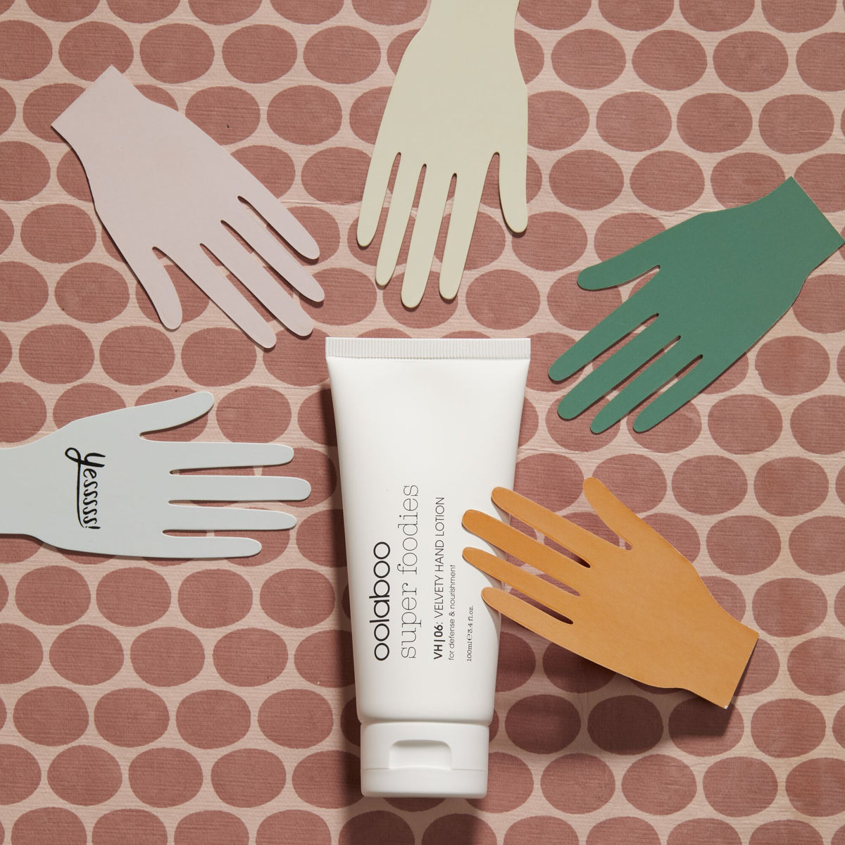 Oolaboo Super Foodies Velvety Hand Lotion tussen papieren handen